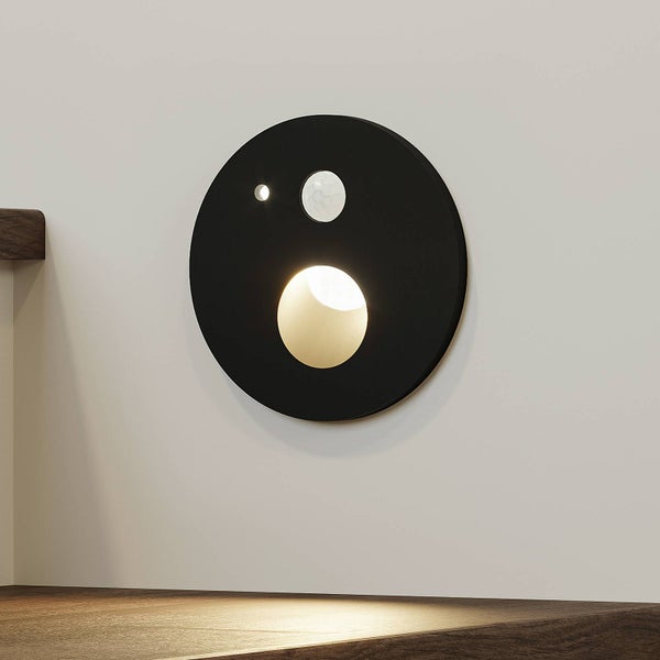 Runde schwarze Außenwandleuchte mit Bewegungsmelder und Lichtsensor, Lichtaustritt nach unten.