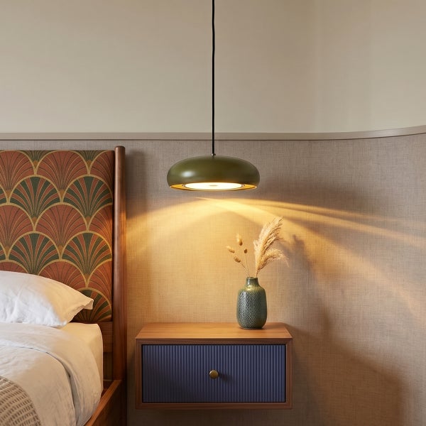 Moderne Hängeleuchte über einem Nachttisch mit einer Vase neben einem Bett mit gepolstertem Kopfteil im Schlafzimmer