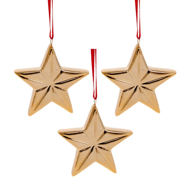 Drei goldene Sterne mit roter Aufhängung als Weihnachtsdekoration.