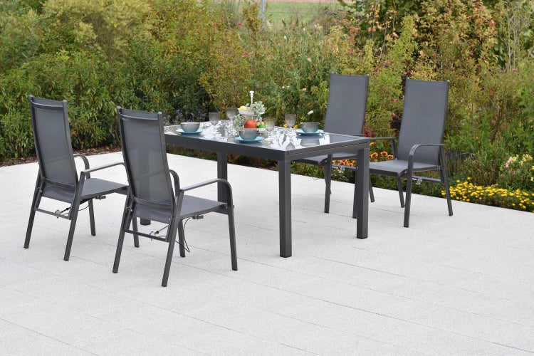 Gartenmöbel-Set bestehend aus einem rechteckigen Tisch mit Glasplatte und vier Hochlehner-Stühlen aus Aluminium und Textilgewebe auf einer Terrasse.