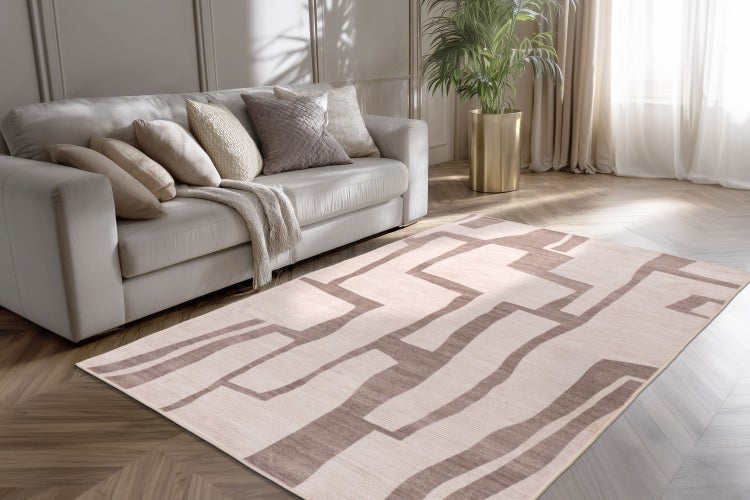 Wohnzimmer mit Sofa, Kissen und Teppich mit abstraktem geometrischem Muster auf Parkettboden.