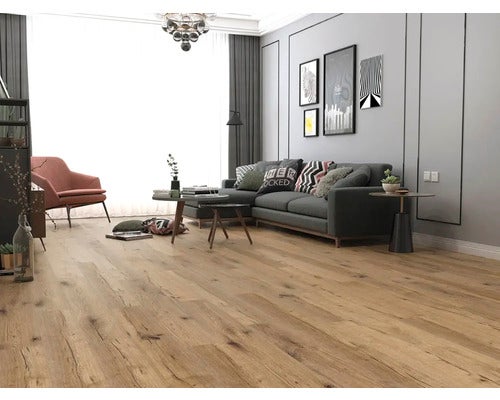 Modernes Wohnzimmer mit hellem Laminatboden in Eichenoptik, grauem Ecksofa, rosa Sessel und großer Fensterfront.