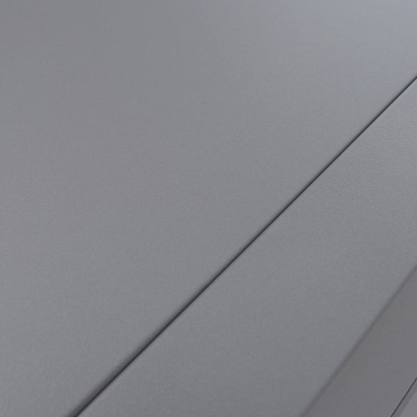 Detailaufnahme einer mattgrauen Oberfläche mit feiner Struktur und einer diagonal verlaufenden Kante.