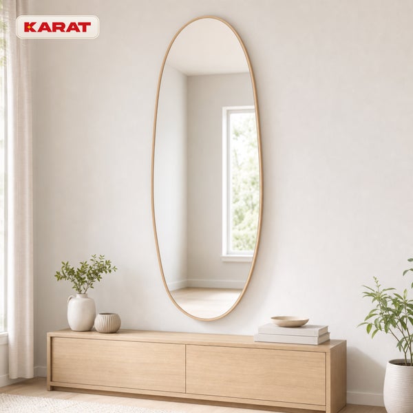 Ovaler Wandspiegel mit Holzrahmen über einem Sideboard in hellem Interieur mit Karat Logo