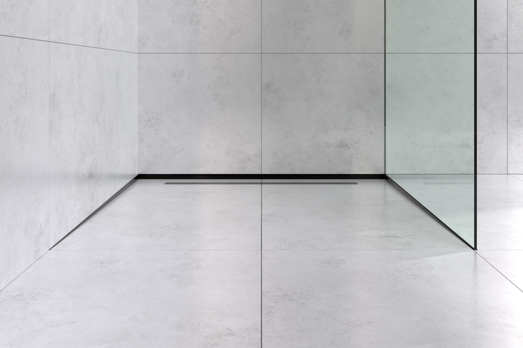 Moderne begehbare Dusche mit bodenebener Duschrinne, Glastrennwand und Fliesen in Betonoptik an Wand und Boden.