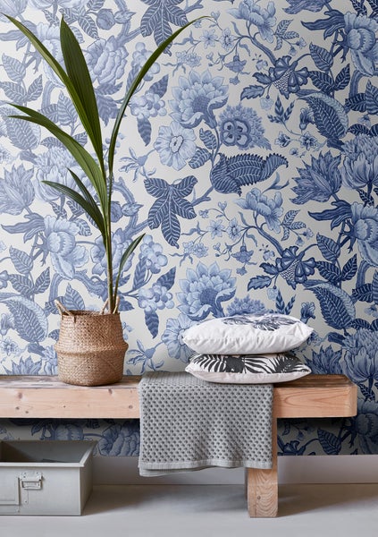 Dekoratives Zimmer mit Blumentapete, Bank, Kissen und Zimmerpflanze