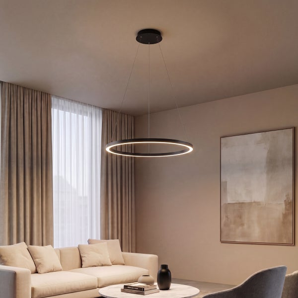 Moderne runde LED Pendelleuchte in einem wohnlichen Wohnzimmer mit Sofa und dekorativen Accessoires.