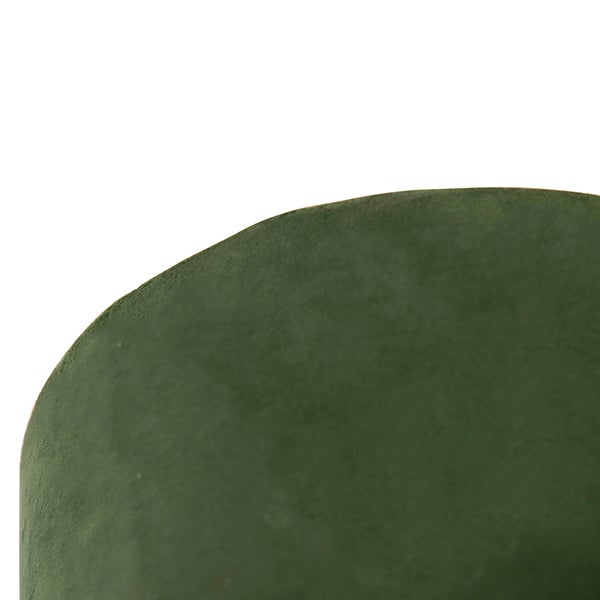 Detailansicht der grünen Samtpolsterung eines abgerundeten Möbelstücks.