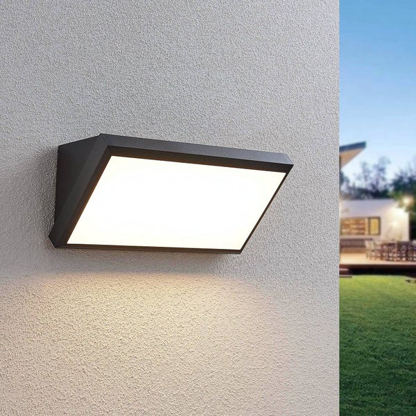 Moderne LED-Außenwandleuchte in Anthrazit, montiert an einer Hauswand mit Blick auf einen Garten.