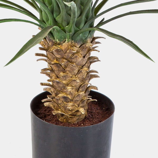 Künstliche Yucca Pflanzen mit langen grünen Blättern und strukturierten braunen Stämmen in schwarzen Töpfen.