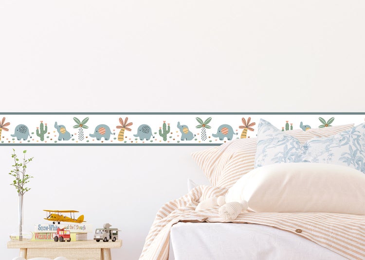 Tapetenbordüre für Kinderzimmer mit Motiven von Elefanten, Palmen und Kakteen an einer Wand über einem Bett.