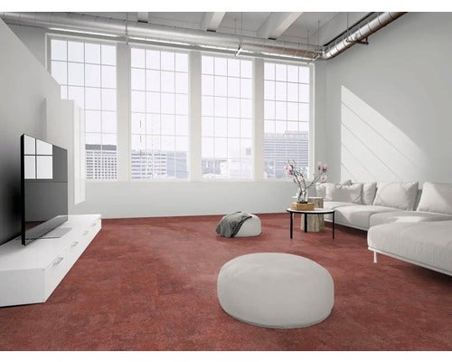 Modernes, helles Wohnzimmer im industriellen Stil mit rötlich-braunem Boden in Steinoptik, weißem Sofa und großen Fenstern.