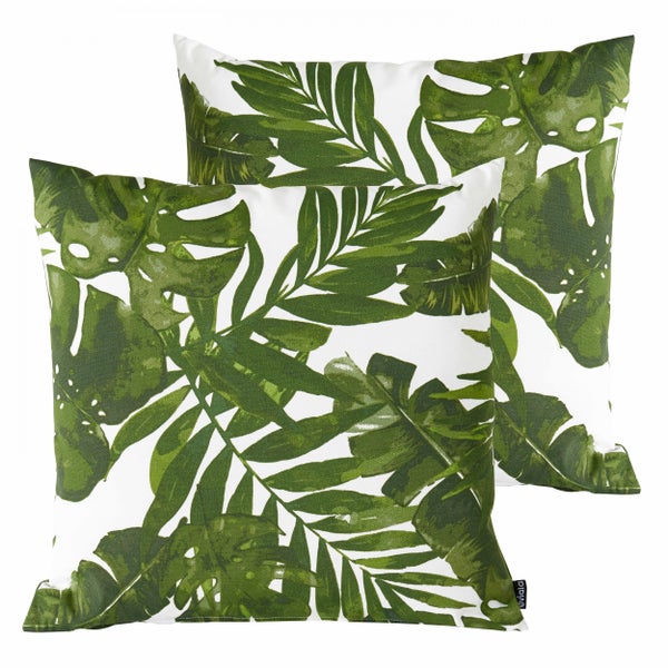 Zwei quadratische Dekokissen mit grünem tropischem Blattmuster aus Monstera- und Palmblättern.