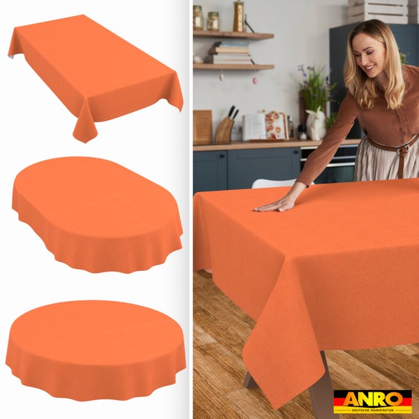 Orangefarbene Tischdecke in rechteckiger, ovaler und runder Form. Eine Frau legt die Decke auf einen Holztisch in einer Küche. ANRO Logo.