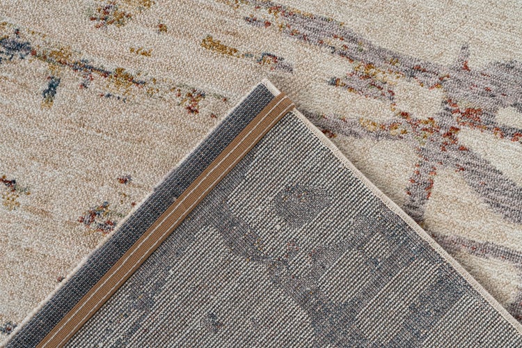 Nahaufnahme eines beigen Teppichs mit abstraktem Muster, weichem Flor und gewebter Unterseite mit Rand.