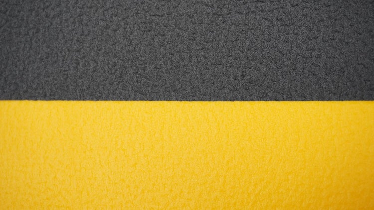 Strukturierter Kantenschutz aus Schaumstoff in Gelb und Dunkelgrau.