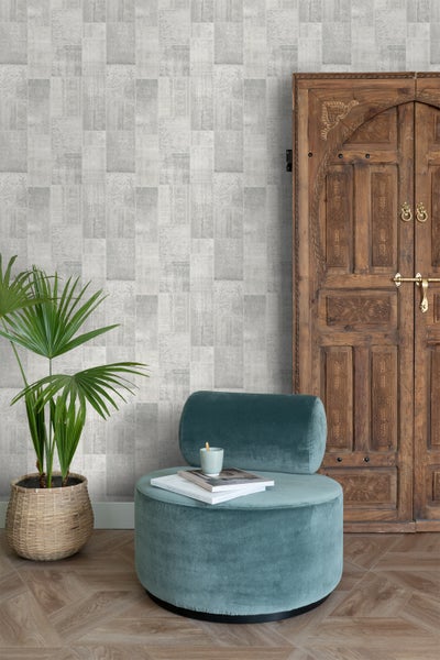 Innenraum mit dekorativer gemusterter Tapete, Holztür und gepolstertem Hocker