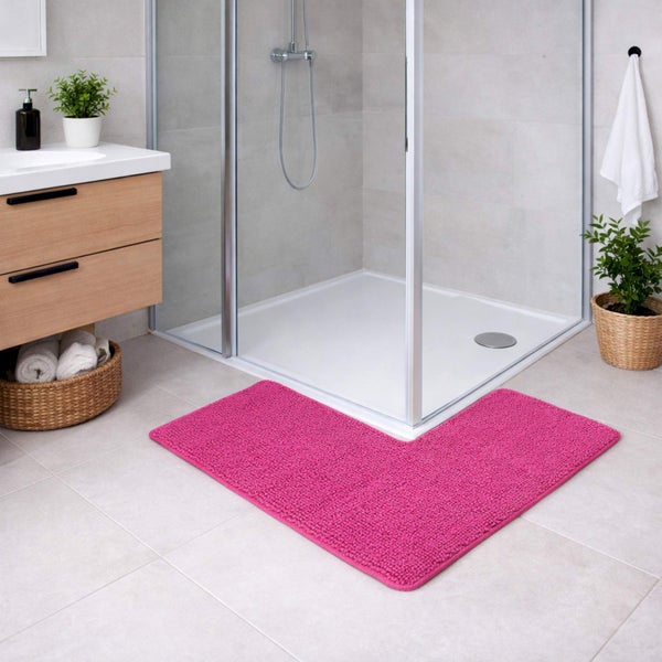 Pinke L-förmige Badematte vor einer Eckdusche aus Glas in einem hellen modern eingerichteten Badezimmer mit Waschtisch aus Holz.