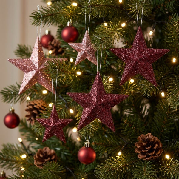 Weihnachtsbaumschmuck Set mit glitzernden Sternen und Weihnachtskugeln an Tannenbaum mit Lichterkette