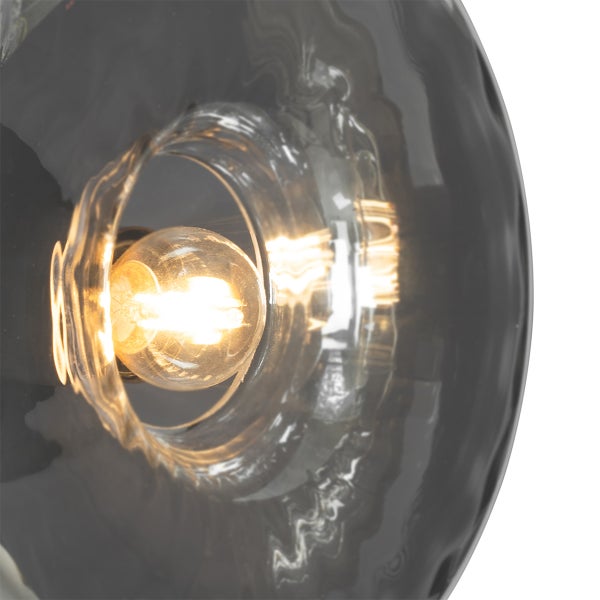 Nahaufnahme einer grauen Glasleuchte mit eingeschalteter Glühbirne