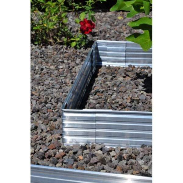 Gewellte Rasenkante aus Metall in einem Kiesbeet zur Beetbegrenzung im Garten.