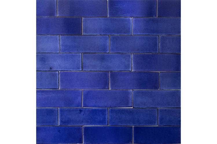 Blaue rechteckige Wandfliesen in Ziegeloptik mit glänzender Oberfläche.