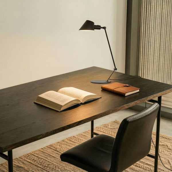 Schreibtisch mit Buch, Notizbuch, Schreibtischlampe und Stuhl für ein organisiertes Arbeitszimmer