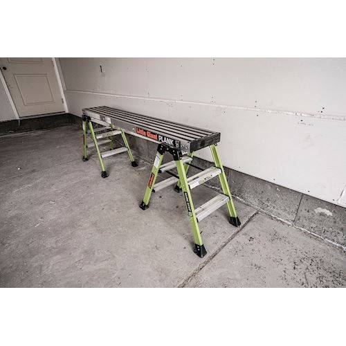 Arbeitsplattform aus Aluminium mit zwei Leitern als Gerüstaufbau in einer Garage.