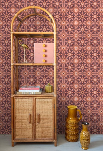 Vliestapete mit floralem Retromuster im Boho-Stil hinter einem Bambusregal mit Dekorationsartikeln und Keramikvasen.