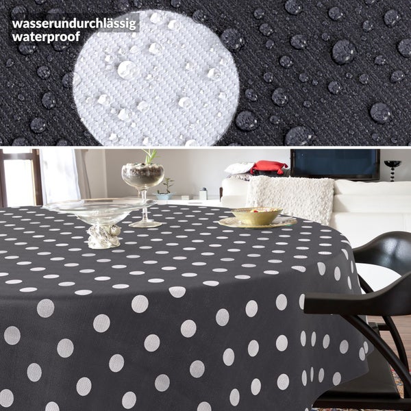 Runde Tischdecke mit Punkten in einem hellen, modernen Wohnzimmer, wasserundurchlässiges Material mit Wassertropfen in der Detailansicht.