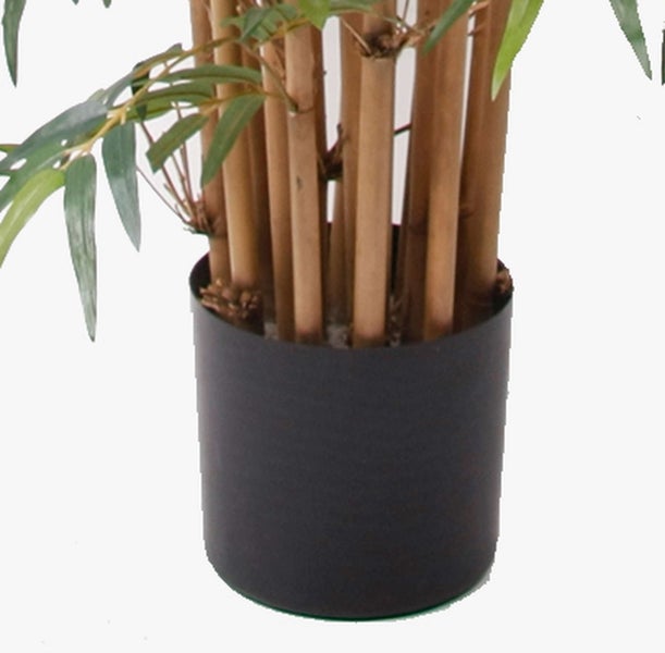 Künstliche Bambuspflanze mit grünen Blättern in einem schwarzen Topf.