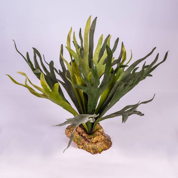 Künstliche Palme mit grünen Blättern und mehreren Stielen.
