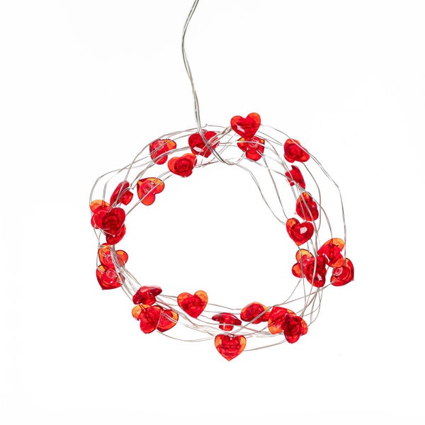 LED-Lichterkette mit roten Herzen an einem dünnen Draht, in Form eines Kreises aufgewickelt.