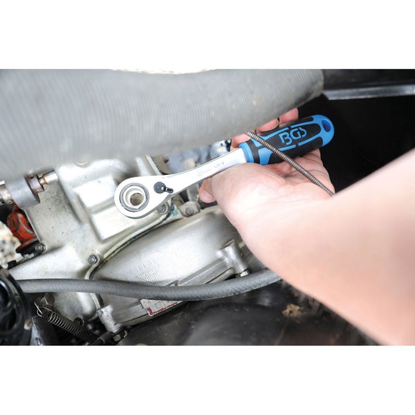 BGS Logo. Schraubenschlüssel mit Knarre in Benutzung am Motorblock