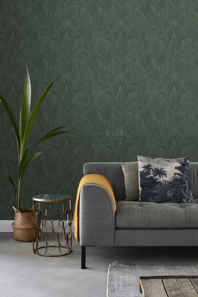 Wohnraum mit grauer Couch, Beistelltisch und Wandtapete mit Palmenblattmuster