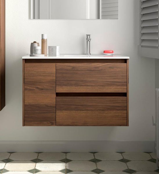 Wandhängender Waschtischunterschrank in Walnuss-Optik mit zwei Schubladen und einer Tür, weißes Waschbecken und Chrom-Armatur.