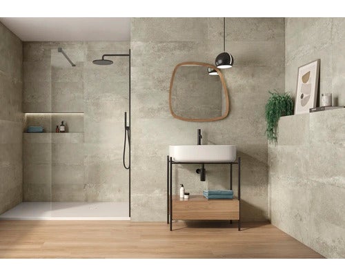 Badezimmer mit Dusche, Waschtisch, Spiegel und Fliesen in Betonoptik