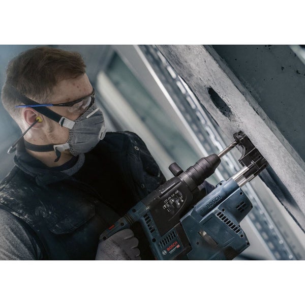 Mann bohrt mit einem Bohrhammer ein Loch in eine Betonwand