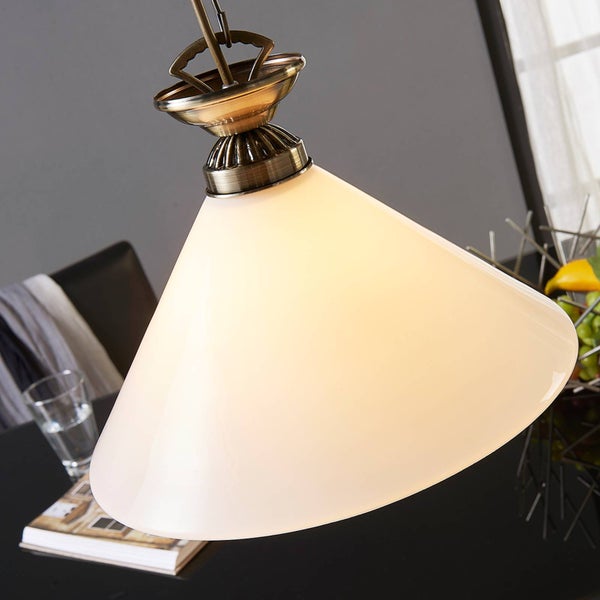 Pendelleuchte mit antik-messingfarbenem Metallsockel und trichterförmigem Glasschirm über einem Esstisch.