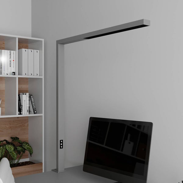 Moderne minimalistische L-förmige Schreibtischlampe an einem hellen und organisierten Arbeitsplatz mit Computermonitor und Regal.