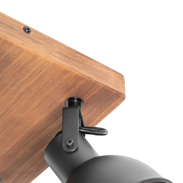Detailaufnahme einer Deckenleuchte mit Holzbrett und schwarzem Lampenkopf