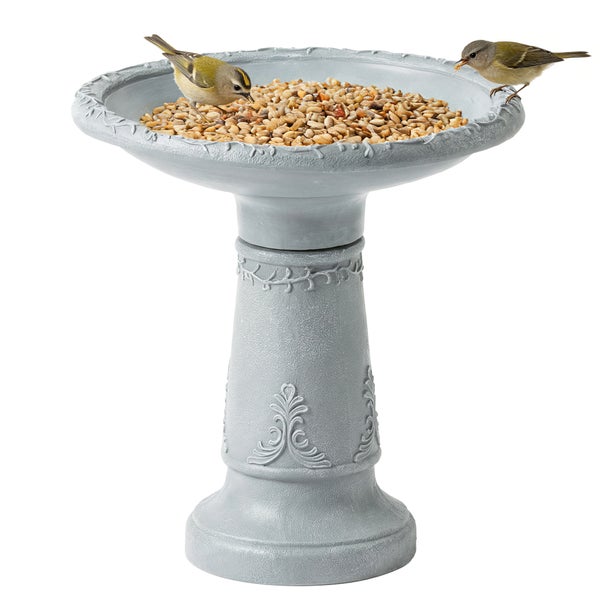 Vogelbad und Futterstation aus grauem Kunststein mit Ornamenten, zwei kleine Vögel fressen Vogelfutter in der Schale.
