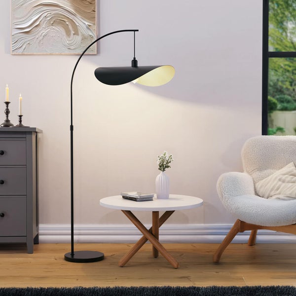 Wohnzimmer mit Bogenlampe, Beistelltisch und Sessel.
