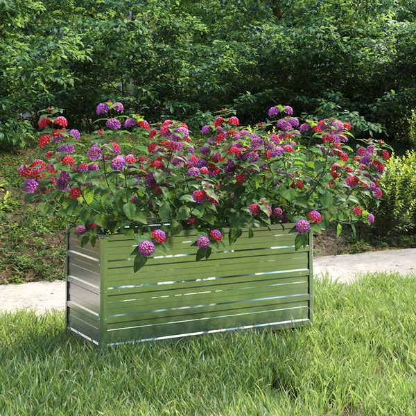 Rechteckiges Hochbeet aus verzinktem Metall mit violetten und roten Blumen auf einer Rasenfläche im Garten.