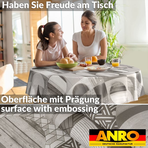 Runde Tischdecke mit grau-weißem geometrischem Muster und geprägter Oberfläche auf einem gedeckten Tisch in einem hellen Raum. ANRO Logo.
