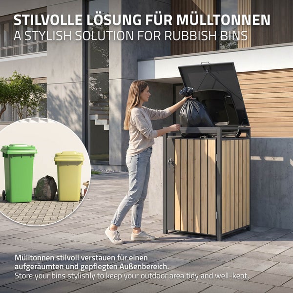 Eine Frau entsorgt einen Müllbeutel in eine moderne Mülltonnenbox aus Holzlatten und Metallrahmen in einem gepflegten Außenbereich vor einem Haus.
