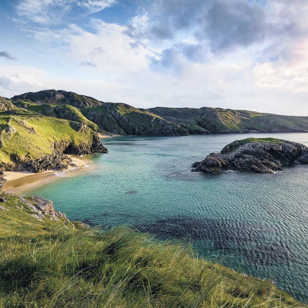 Landschaftsbild mit Küste, Bergen und klarem Wasser