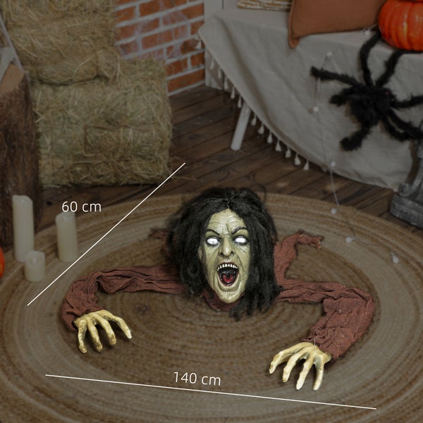 Halloween Dekoration mit Zombiefigur auf einem Teppich, umgeben von Heuballen und Kerzen.