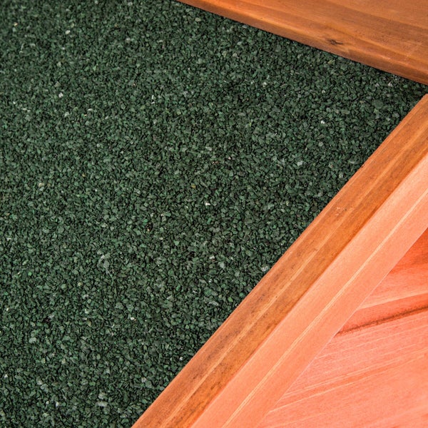 Nahaufnahme von grüner Dachpappe mit mineralischer Bestreuung an einer Holzkante.