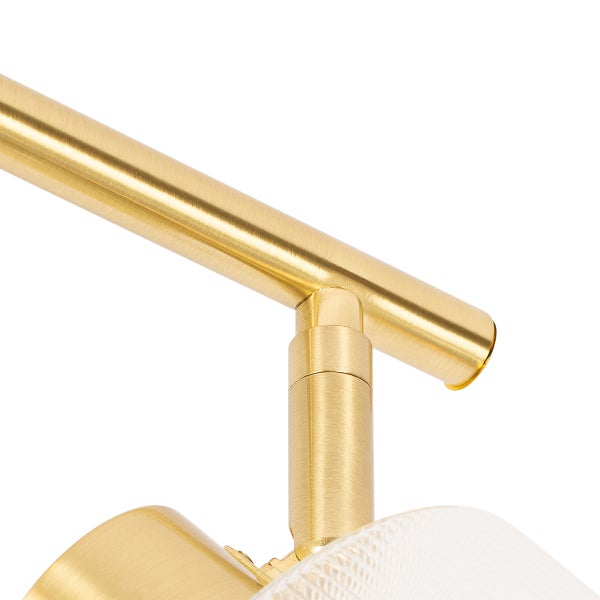 Detailaufnahme einer goldenen Deckenleuchte mit transparentem Lampenschirm.